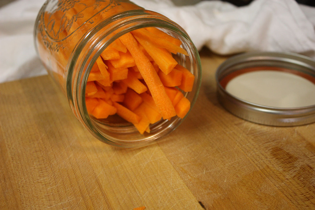 Raw carrot sticks placed into a mason jar.