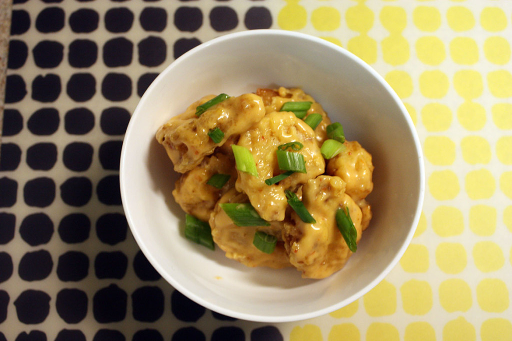 Bang Bang Shrimp in a bowl garnished with green onions.