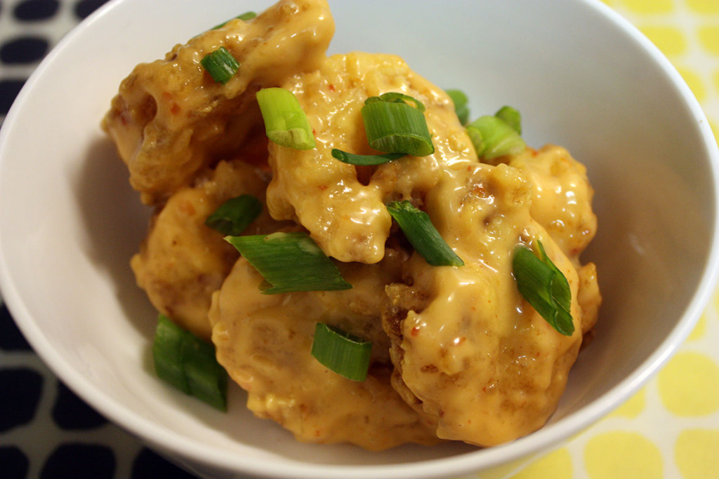 Bang Bang Shrimp in a bowl garnished with green onions.