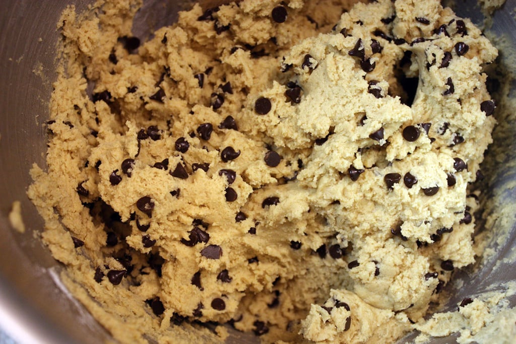 Chocolate chip cookie dough in metal bowl.