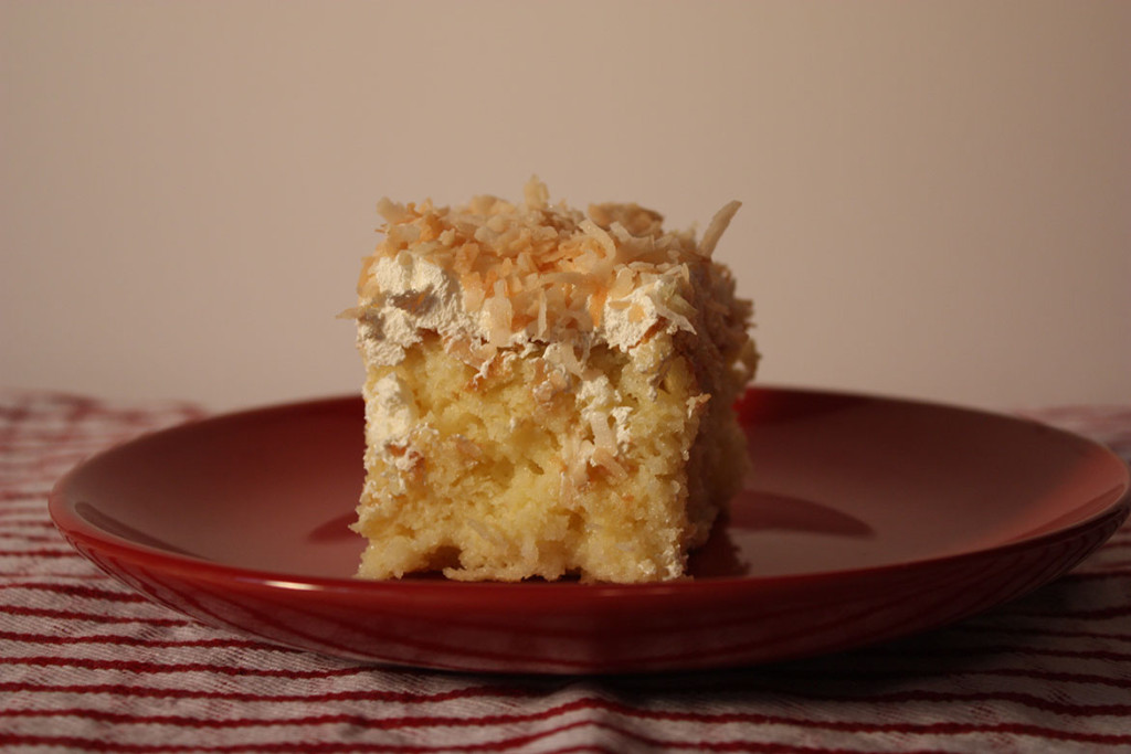 Slice of the coconut cake on a red plate.
