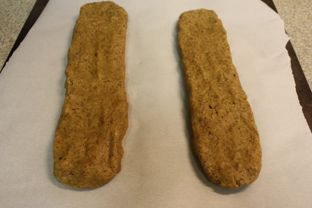 Espresso biscotti dough formed on a parchment paper lined baking sheet.