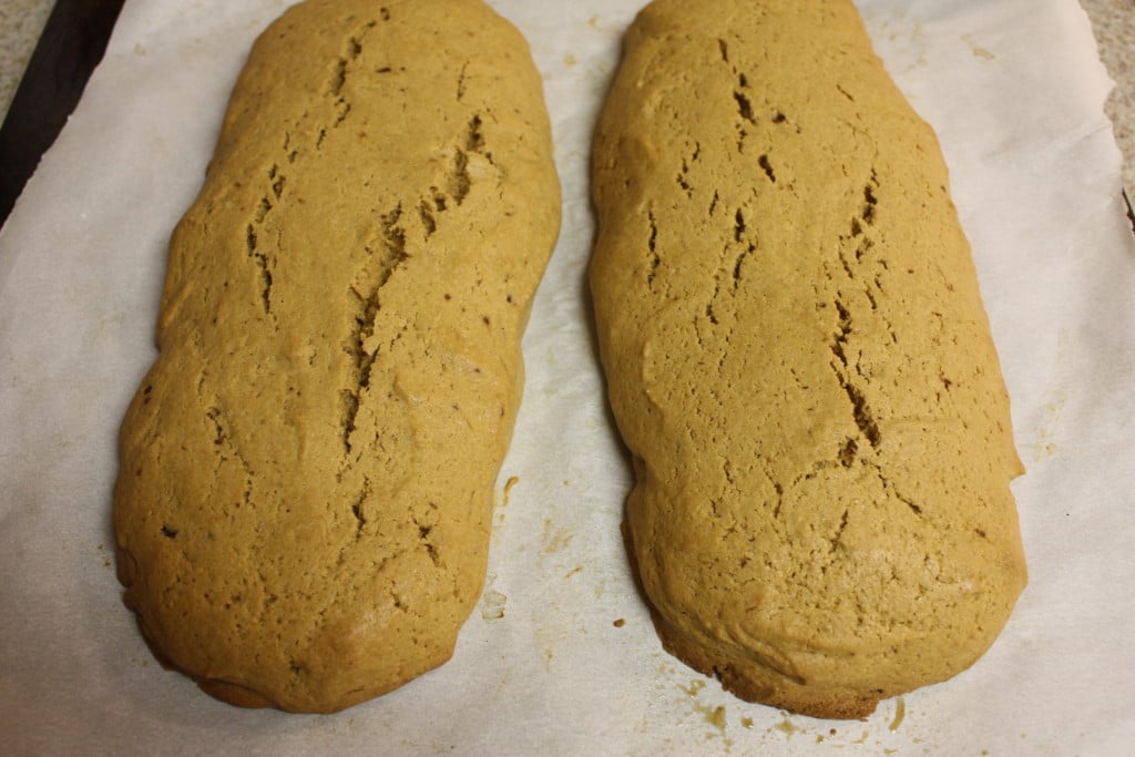 Baked espresso biscotti dough on a parchment paper lined baking sheet.