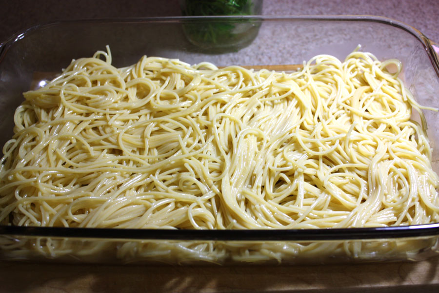 cooked Spaghetti noodles in a glass baking pan