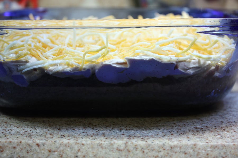 Black bean taco dip ingredients layered in a baking dish.