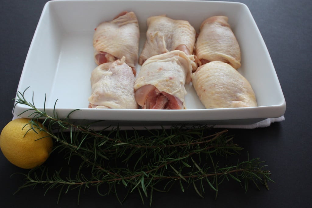 Raw chicken thighs in a white baking dish.