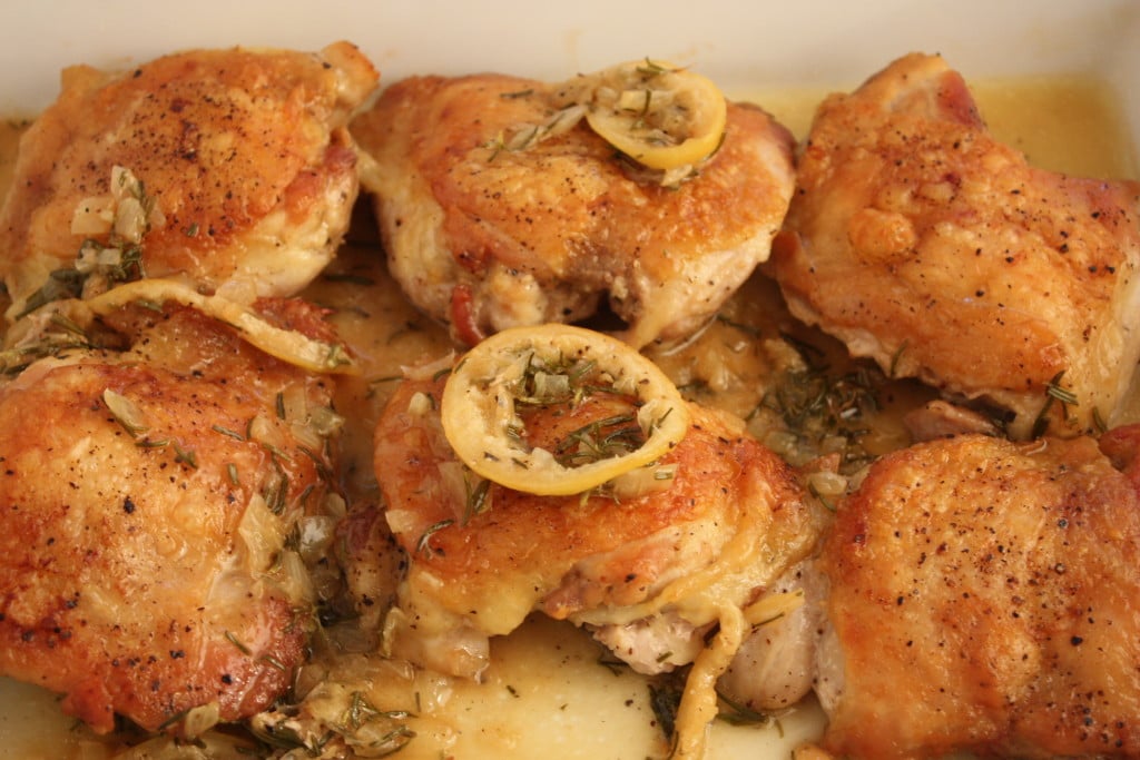Roasted Chicken Thighs with Rosemary and Lemon in a white baking dish.