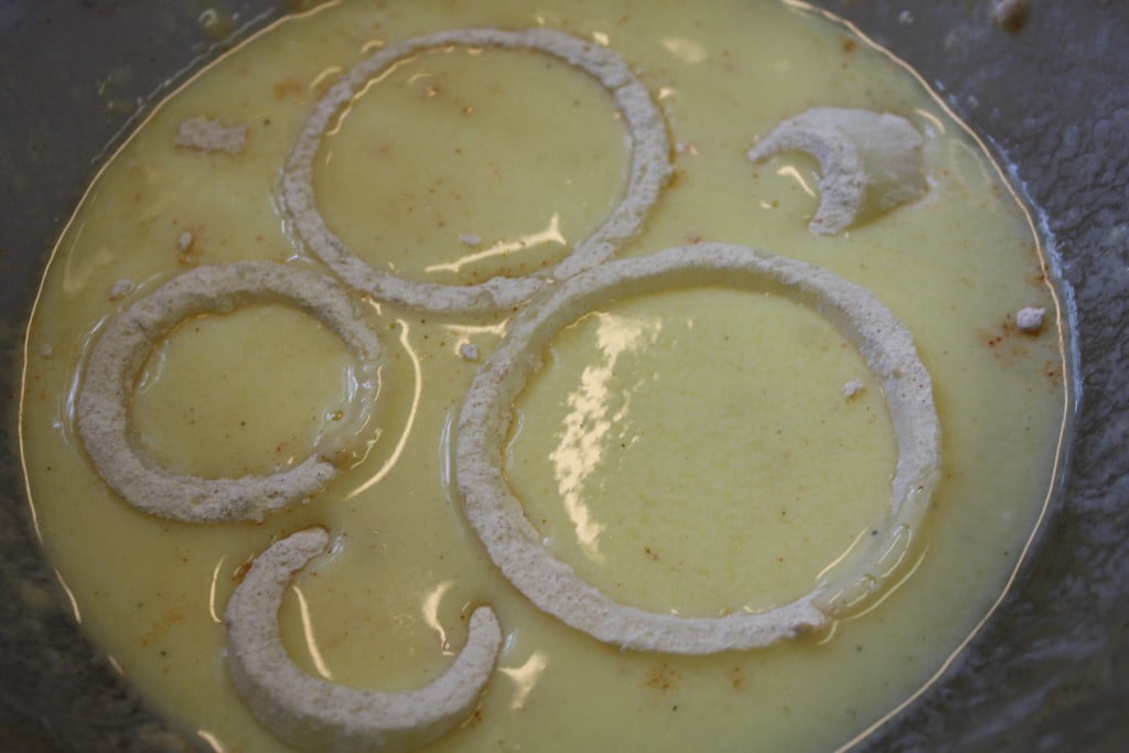 Floured onion rings in the buttermilk batter.