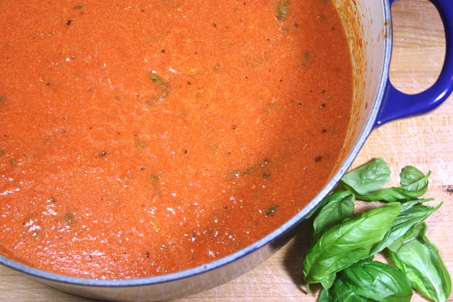 Creamy tomato basil soup in a blue dutch oven.