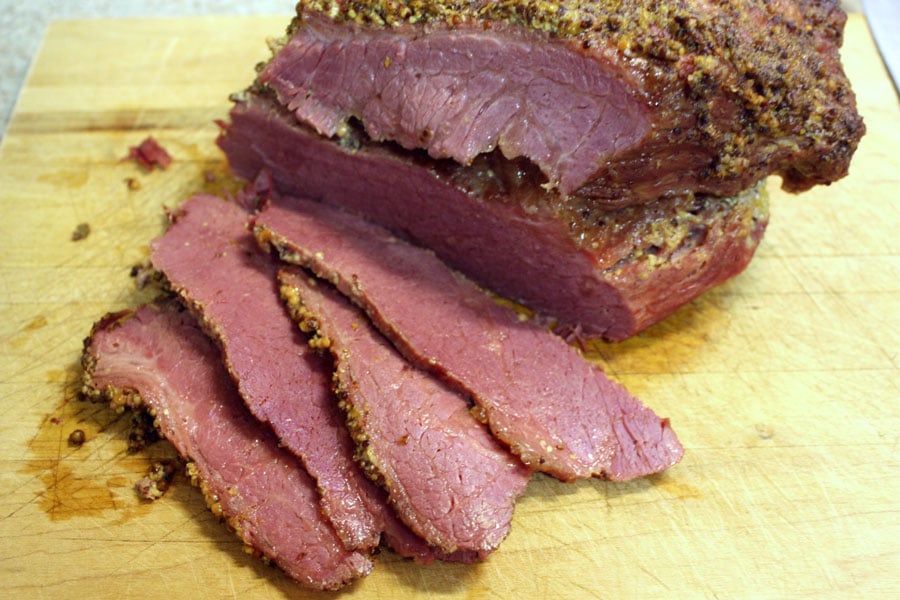 Corned Beef with Mustard Sauce sliced on a wooden cutting board