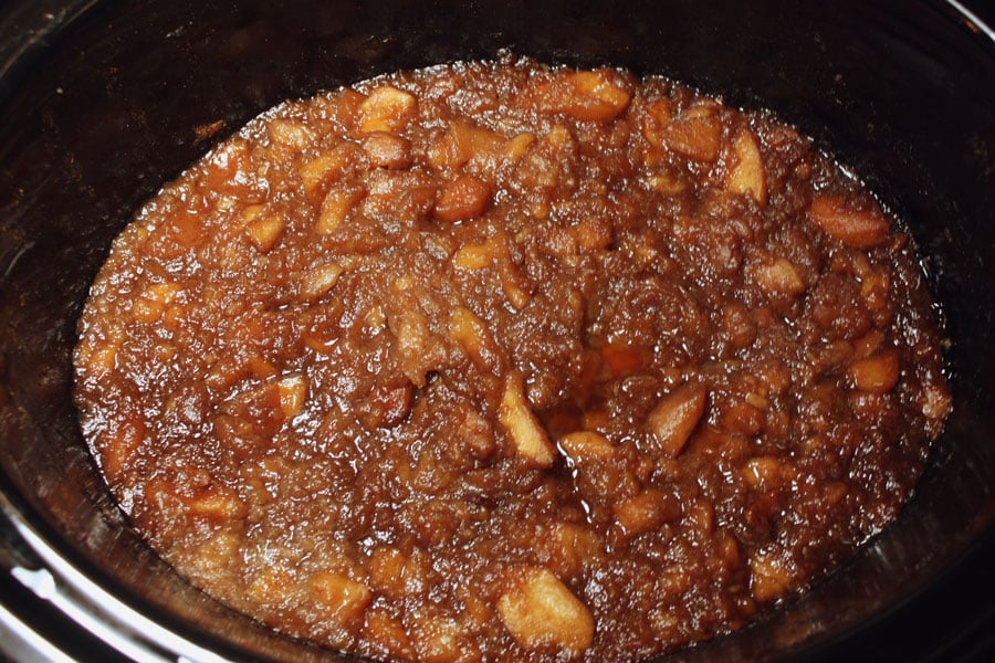 Cooked chunky Apple Butter in the crock of a slow cooker.