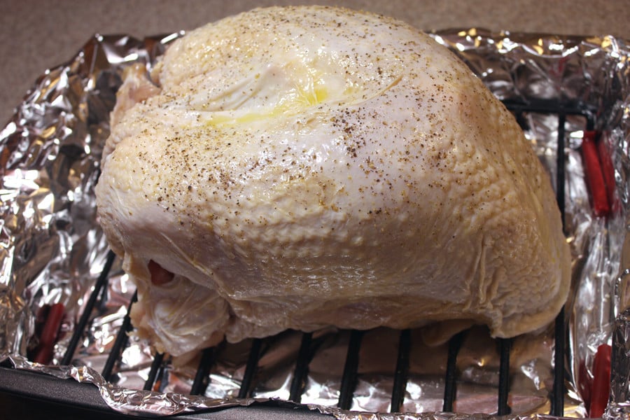 Turkey breast on a wire rack in a foil lined roasting pan