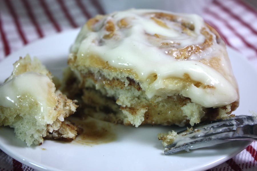 Cinnamon Roll on a white plate with a fork.