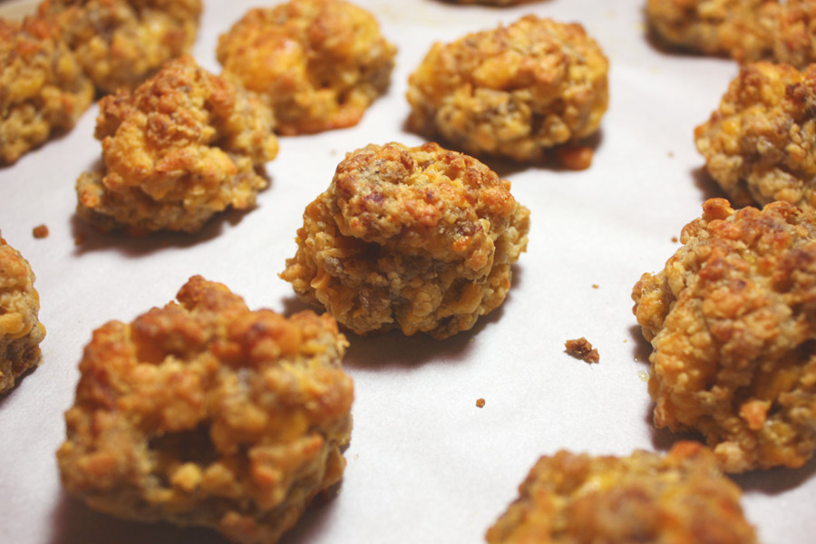 Sausage balls baked on a parchment paper lined baking sheet.