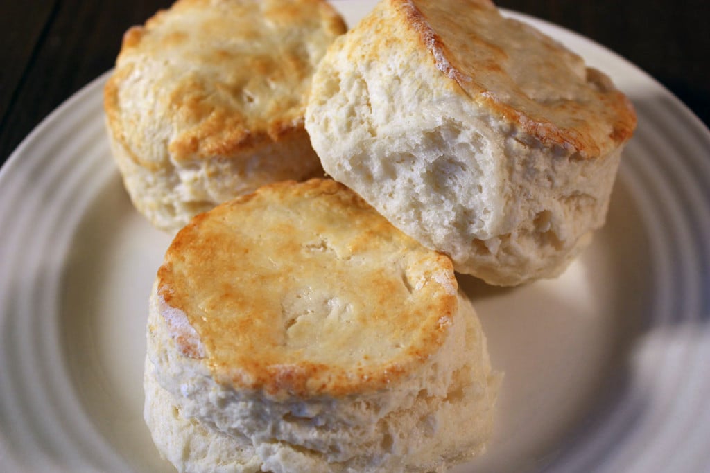 Homemade Buttermilk Biscuits stacked on a plate.