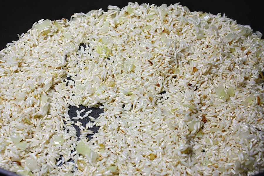 Rice browning in large skillet with sauteed onions