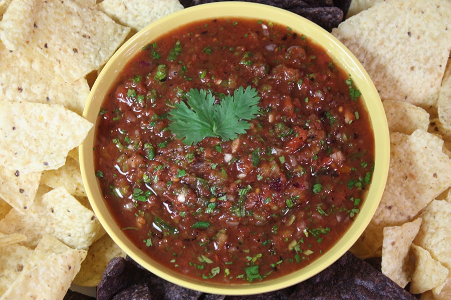 Fire Roasted Salsa in a yellow bowl surrounded by tortilla chips.