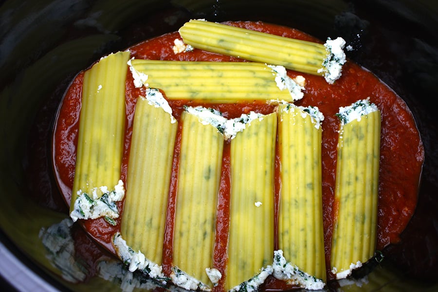Spinach Ricotta Manicotti on top of marinara sauce in the crock of a slow cooker