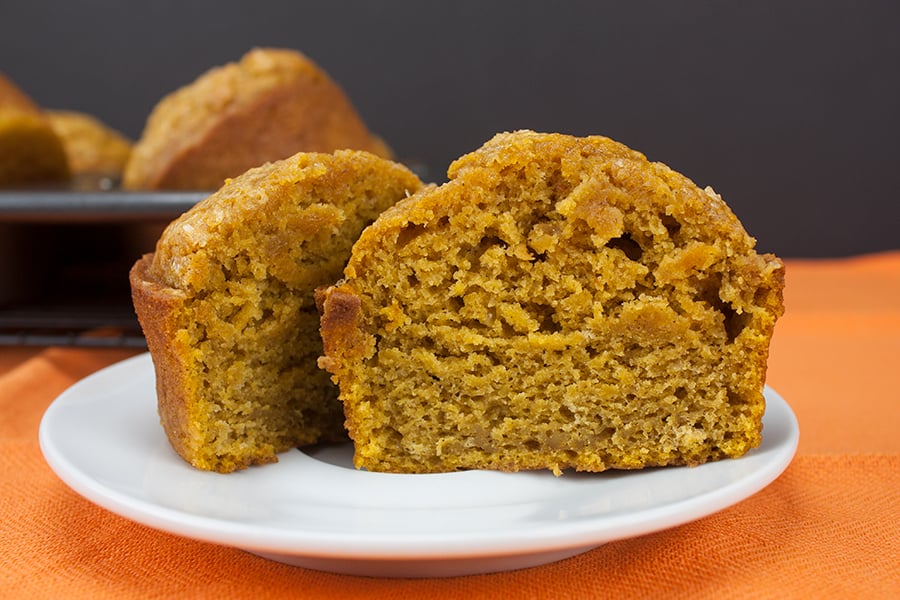 Bakery Style Pumpkin Muffin sliced in half on white plate