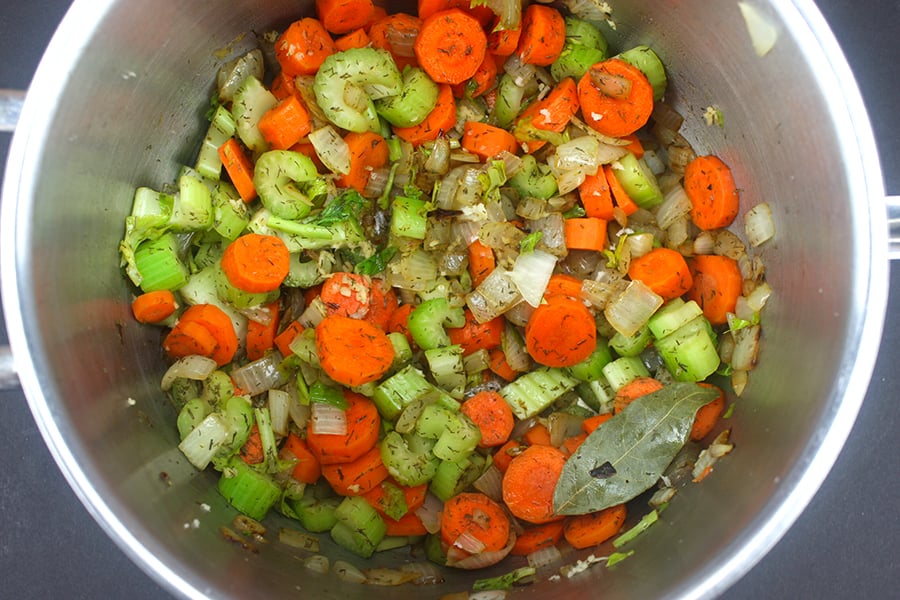 Vegetable Dumpling Soup - onions, carrots, and celery sautéing in a large pot