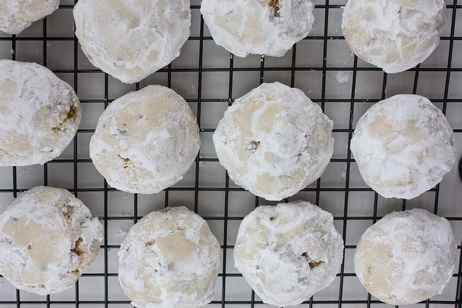 Italian Butterball Cookies coated in powdered sugar on a wire rack