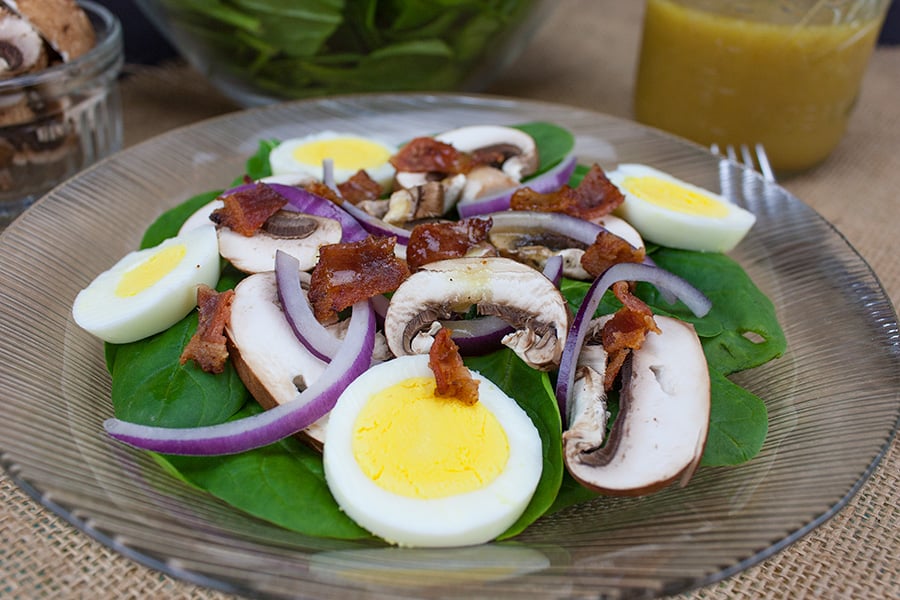 Spinach Salad with Curry Mustard Vinaigrette - salad on a glass salad plate
