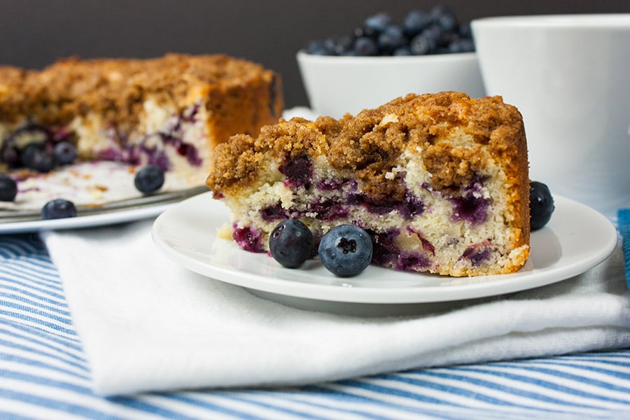 Blueberry Streusel Coffee Cake on a white platter with a coffee cup.