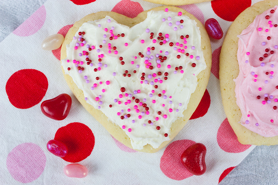 Soft Frosted Sugar Cookies on a pink and white polka dotted cloth.