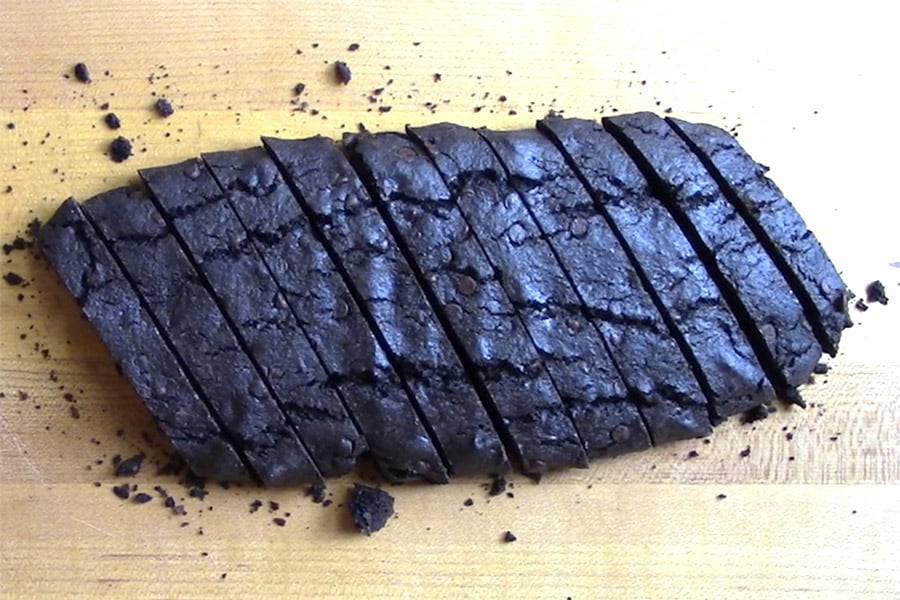 Chocolate biscotti sliced on a wooden cutting board.