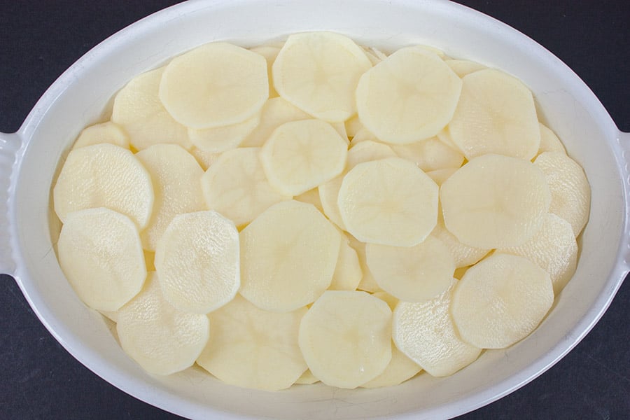 Creamy Herb Potatoes Gratin - potatoes laid in an oval white casserole