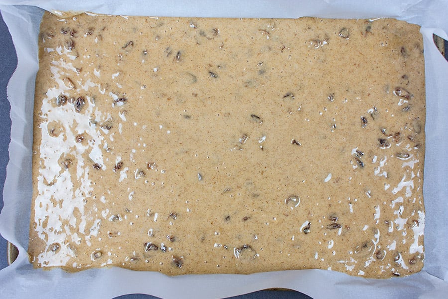 Old fashioned Raisin Bars batter in a parchment lined baking pan