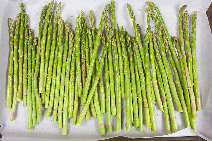 Horseradish Sour Cream Roasted Asparagus - raw asparagus on a parchment lined baking sheet
