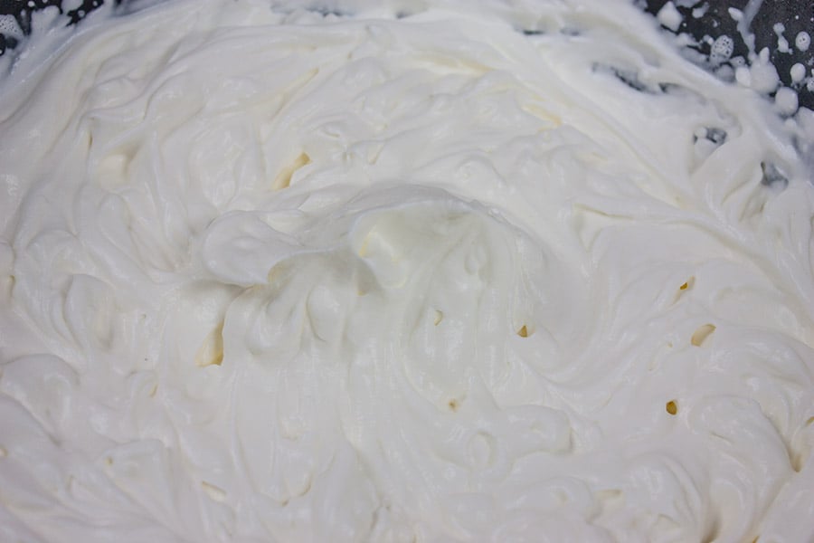 homemade whipped cream in glass mixing bowl