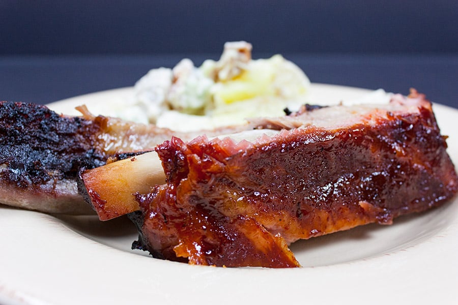 Closeup of the St Louis Style Ribs on a plate with potato salad.