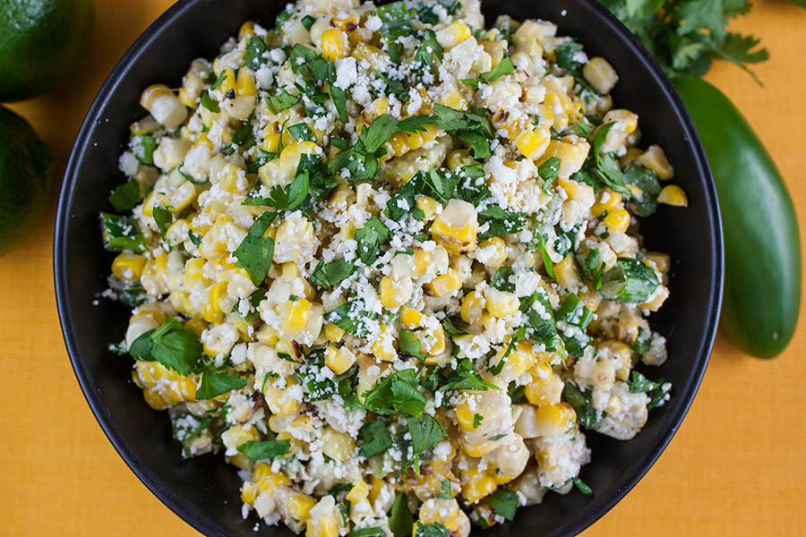 close up of Grilled Mexican Street Corn Salad in black bowl garnished with chopped cilantro