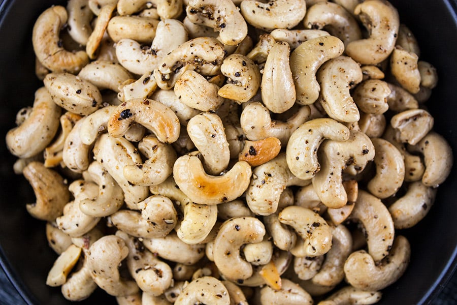 close up of Salt and Pepper Roasted Cashews in black bowl