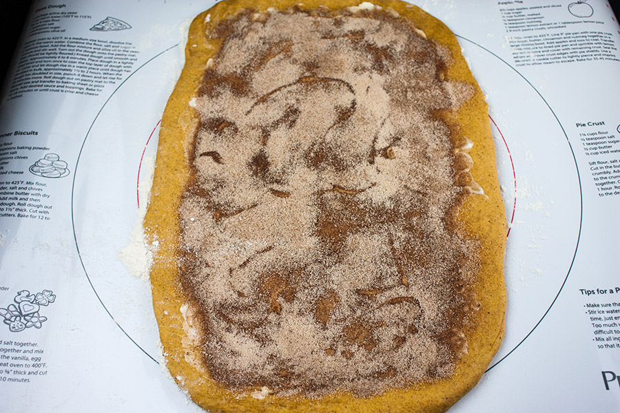 Dough rolled out on a pastry mat with filling spread on the middle.