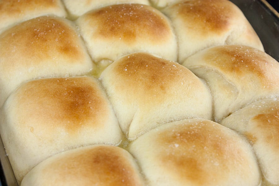 baked one hour dinner rolls brushed with butter and sprinkled with salt in a baking dish