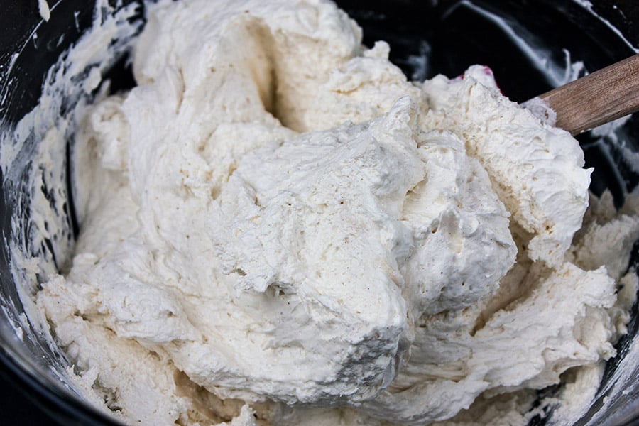spiced cream cheese and whipped cream filling for pumpkin cake in glass mixing bowl