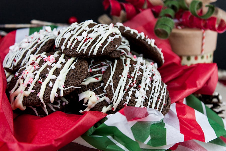 Chocolate peppermint cookies stacked in a Christmas tin with red, white and green tissue paper