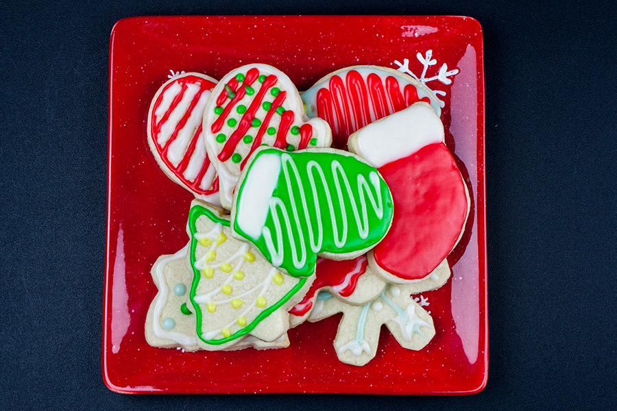 Cut out sugar cookies on red plate.