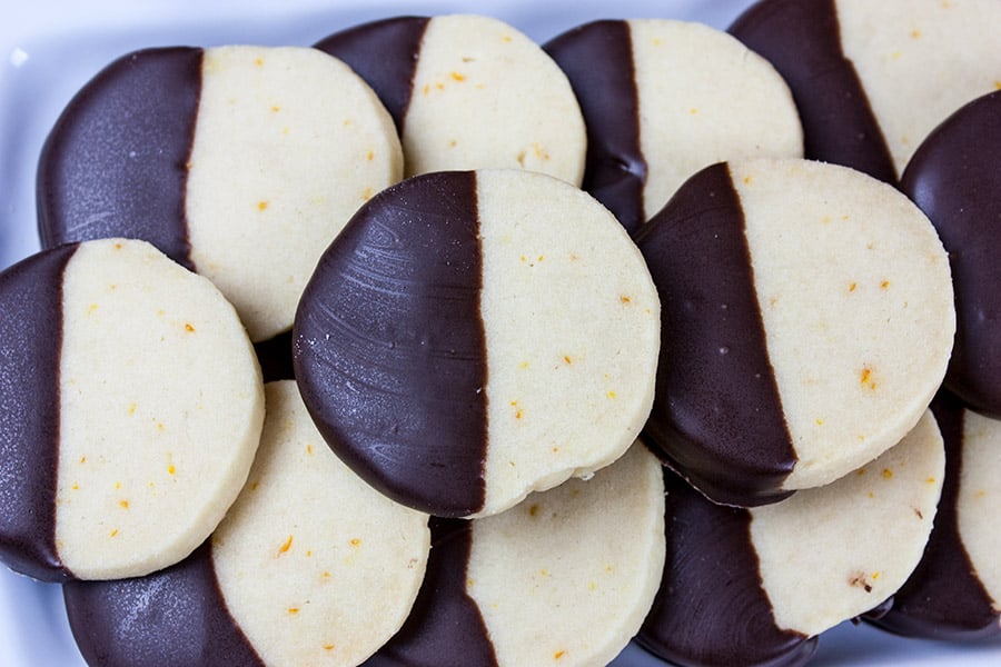 Chocolate Orange Shortbread Cookies stacked on a white platter.