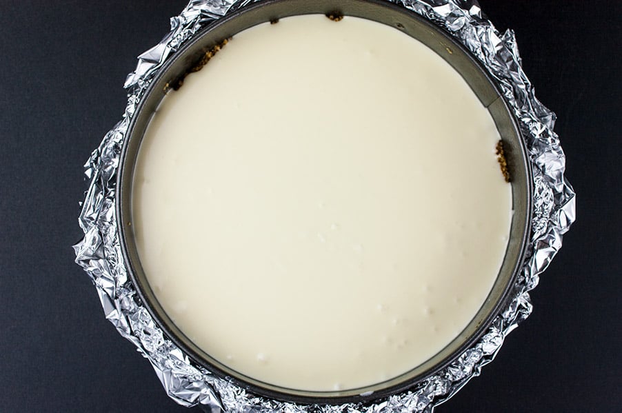 Smooth and Creamy Cheesecake - cheesecake batter in a springform pan wrapped in heavy duty foil