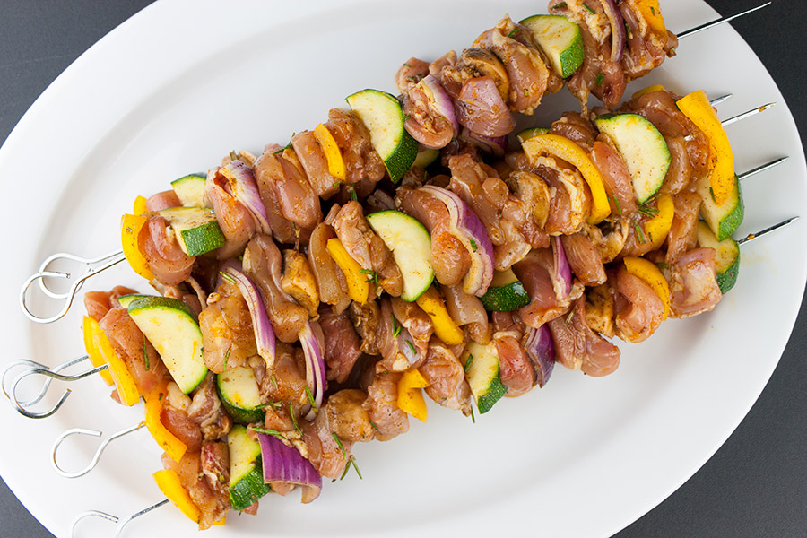 Orange Rosemary Chicken Kebabs skewered on a white platter