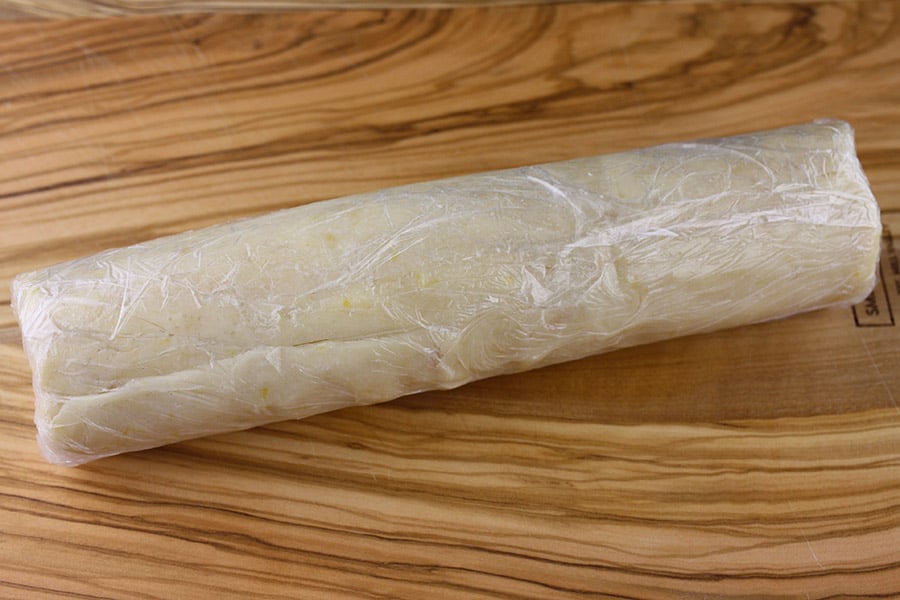 Lemon Sandwich Cookie dough rolled in plastic wrap and chilled overnight