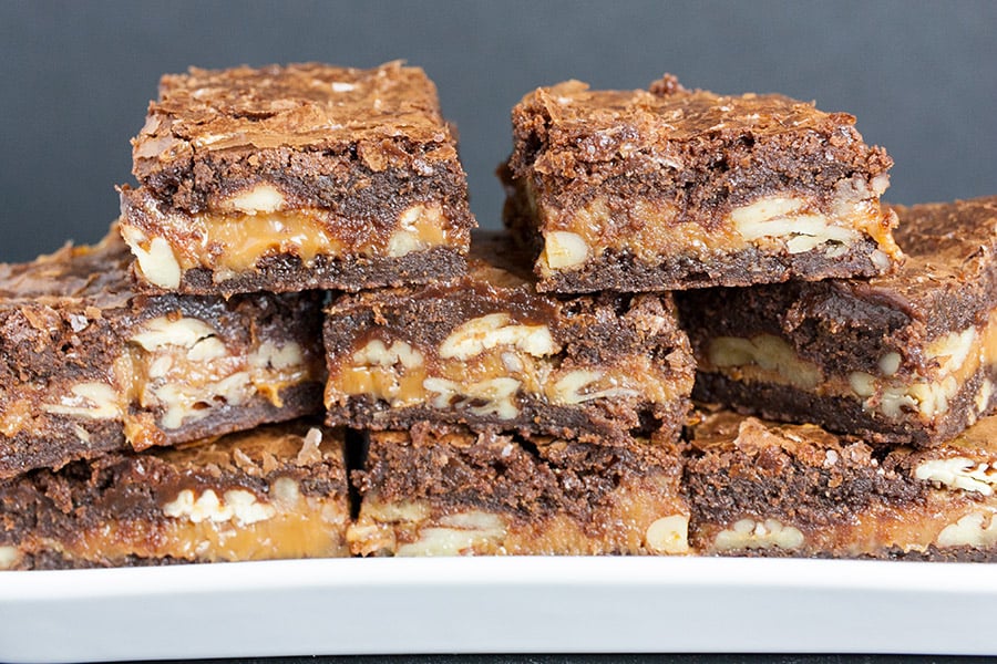Ultimate Turtle Brownies stacked on white plate