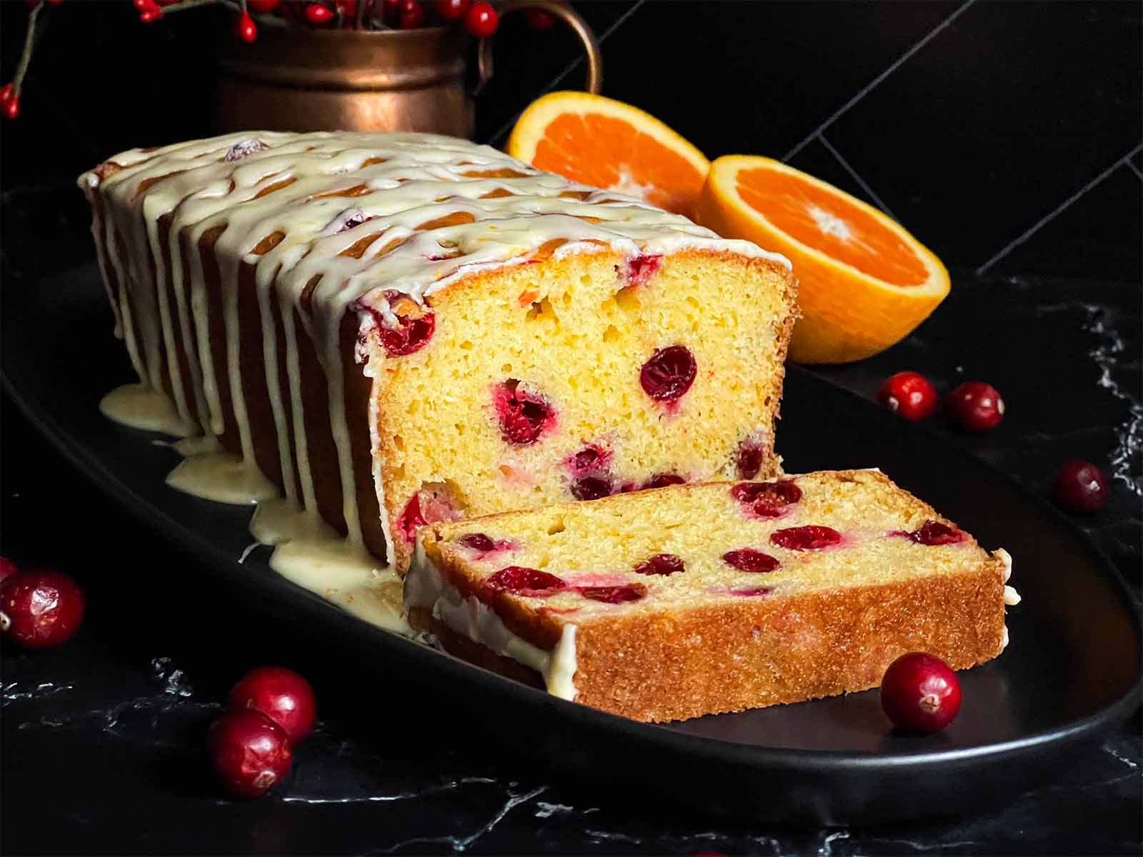 Cranberry orange bread on an oval dark platter.