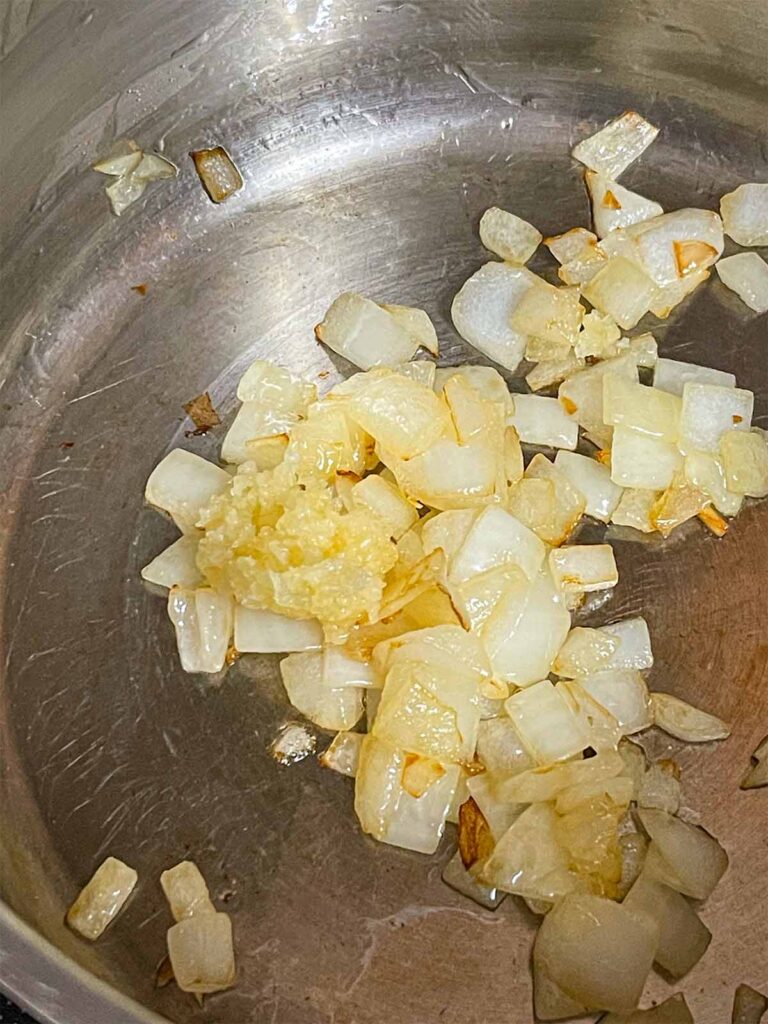 Onions and garlic cooking in a pot.