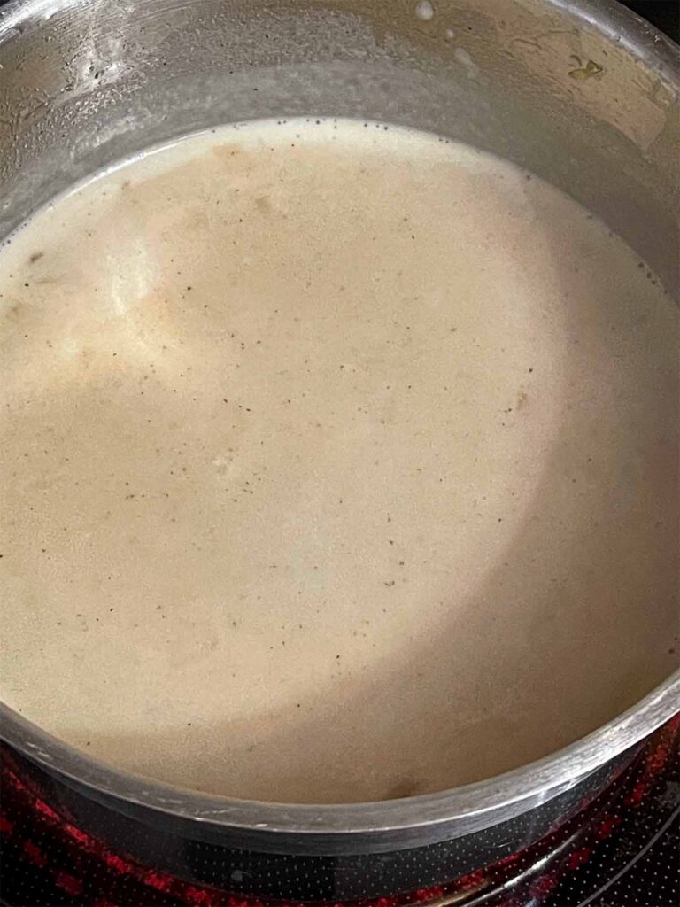 A tetrazzini sauce cooking in a pot.