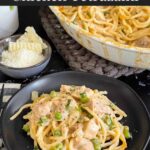 Chicken tetrazzini in a white baking dish with a serving on a dark plate.